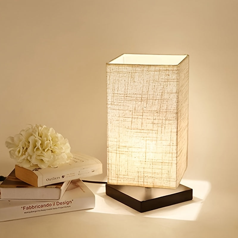 A Compact Table Lamp for The Bedroom, Featuring a Straightforward Design with a Square Fabric Shade. This Desk Lamp Is Suitable for Reading And Can Be Used in Bedrooms, Living Rooms, Offices
