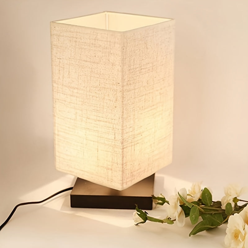 A Compact Table Lamp for The Bedroom, Featuring a Straightforward Design with a Square Fabric Shade. This Desk Lamp Is Suitable for Reading And Can Be Used in Bedrooms, Living Rooms, Offices